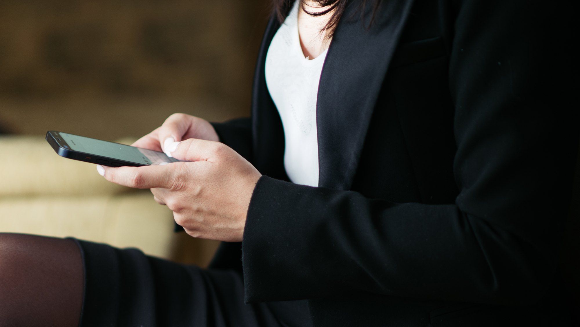 Hands typing a message on a smartphone