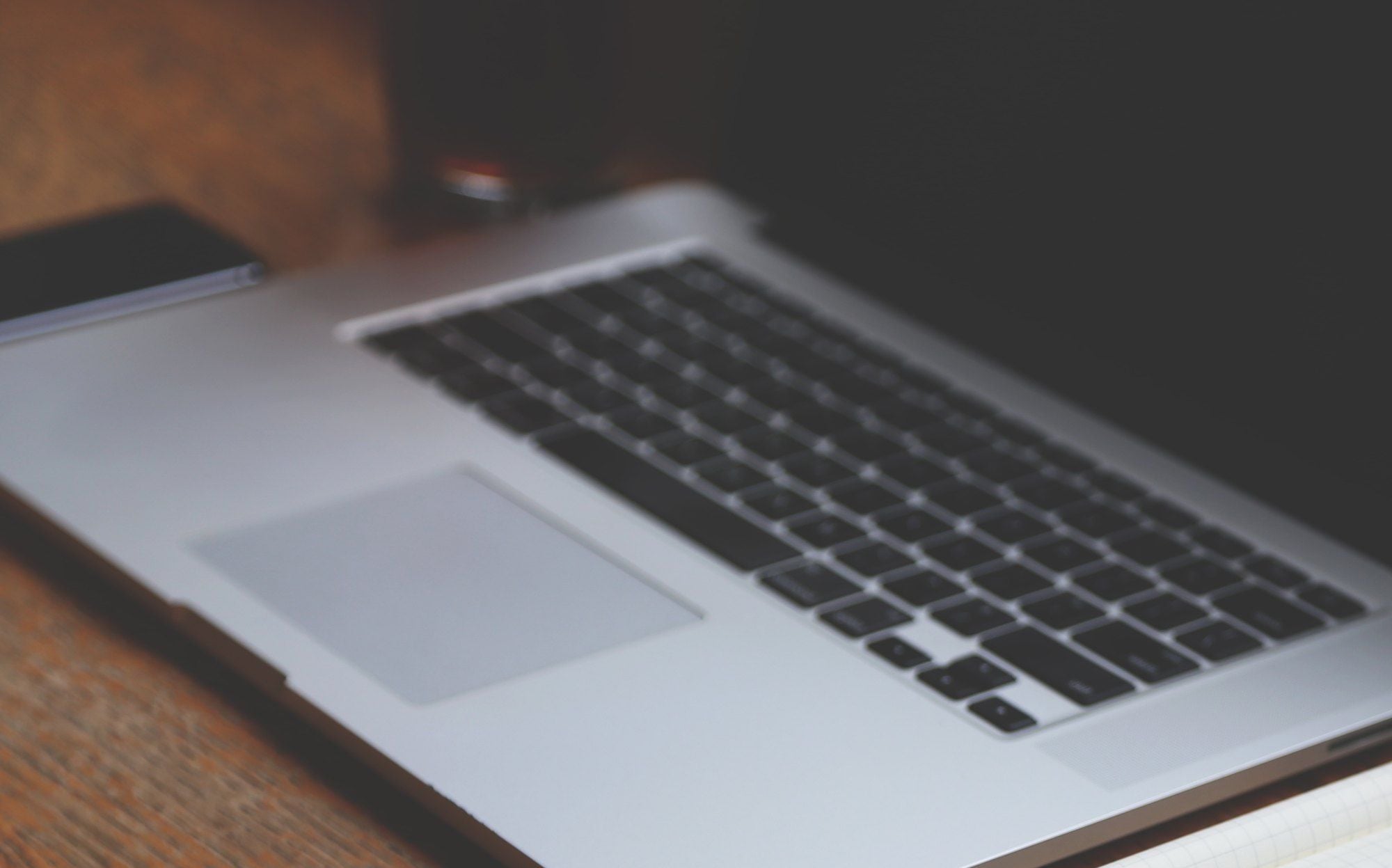 An open laptop keyboard on a wooden desk