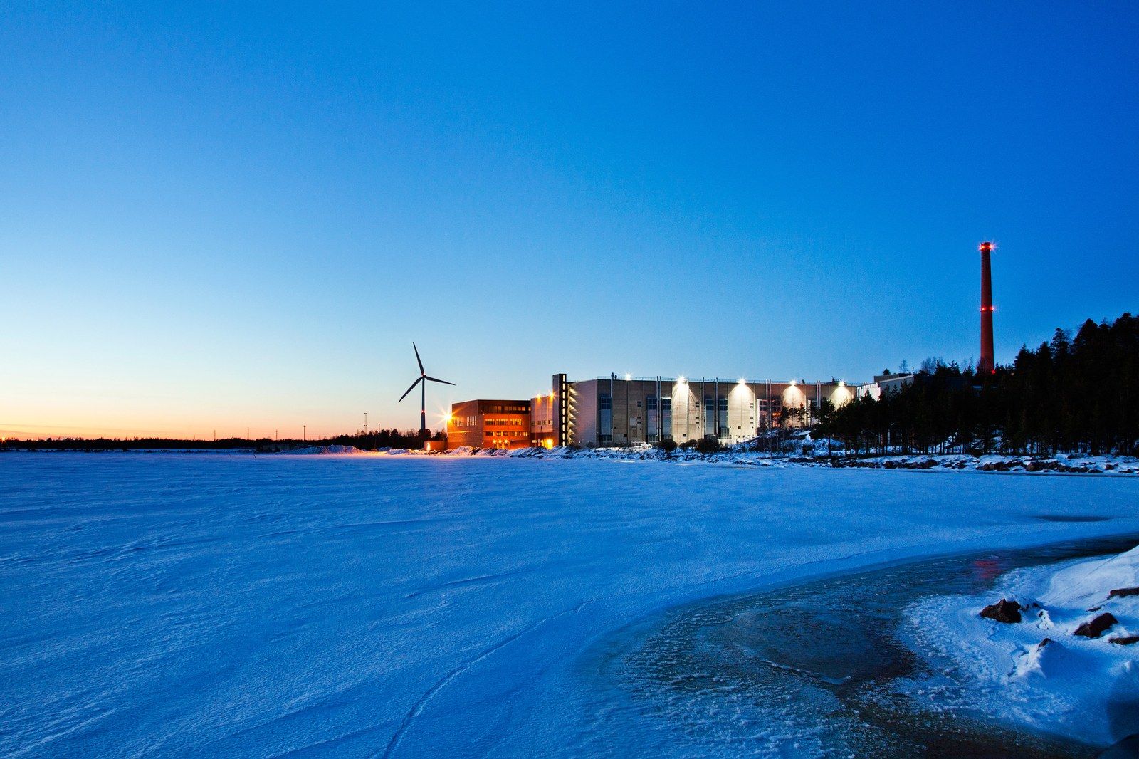Google's data center in Hamina, Finland, beside a frozen shoreline at dusk