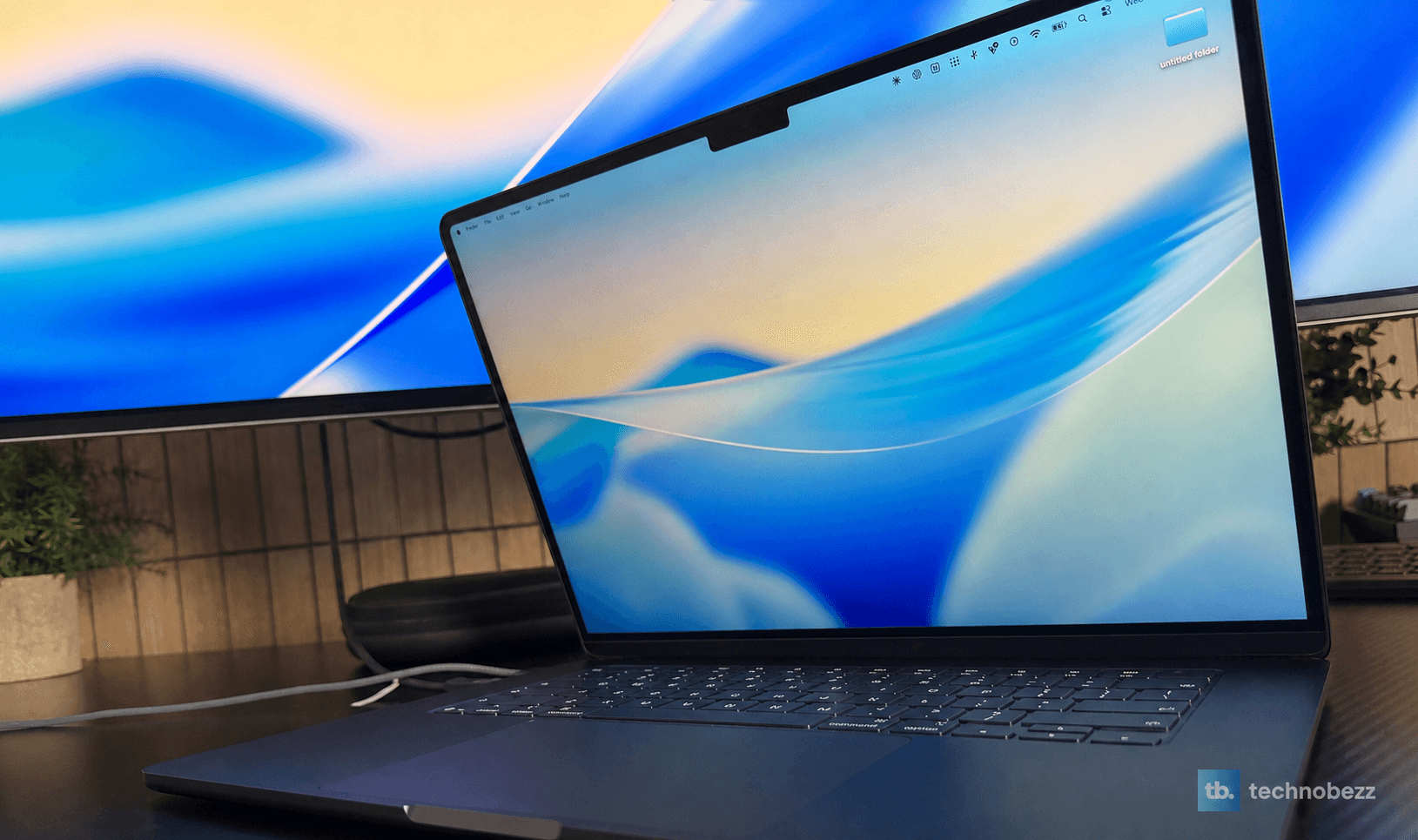 Open 15-inch MacBook Air M5 positioned in front of an external ultrawide display