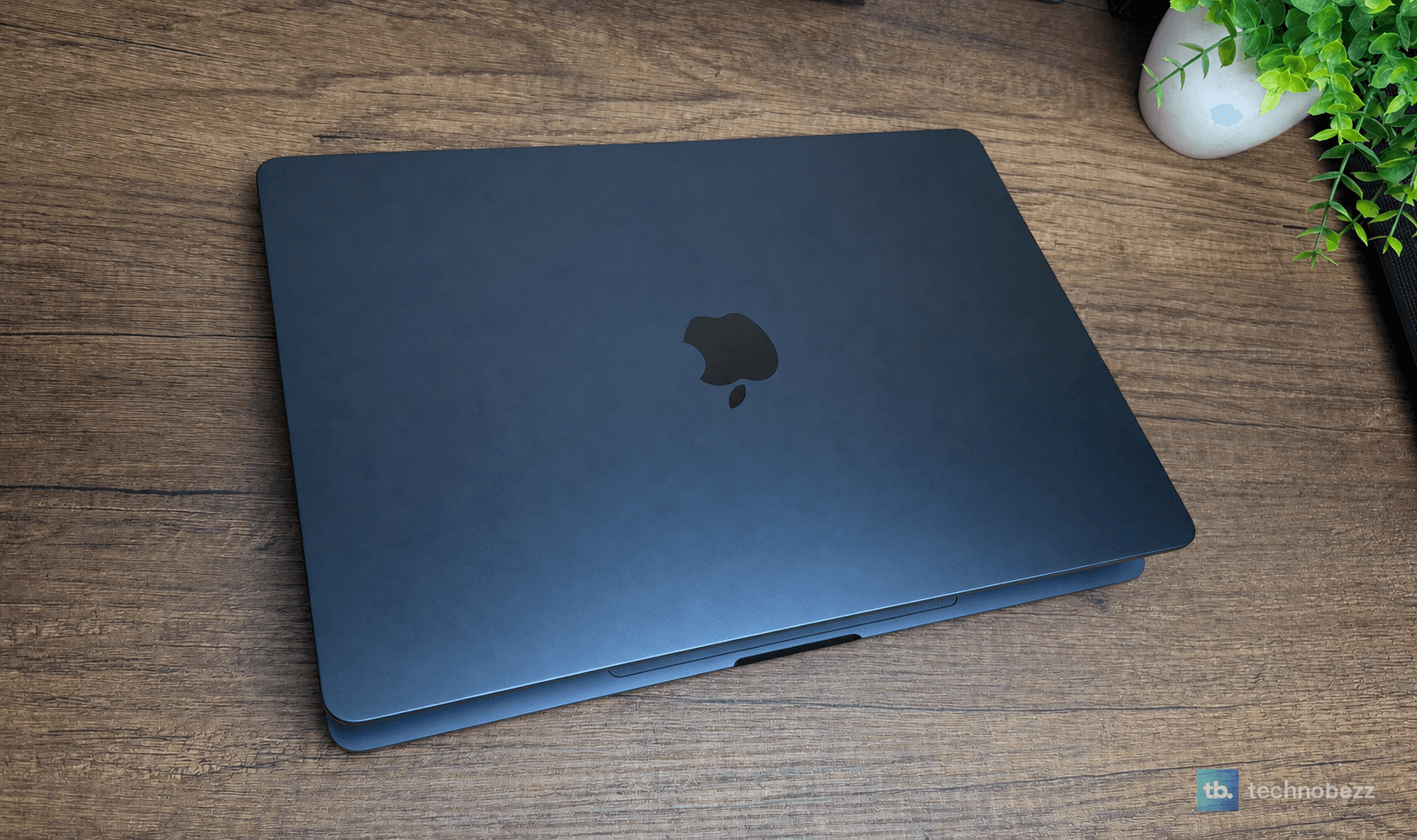 Closed 15-inch MacBook Air M5 in Midnight on a wooden desk