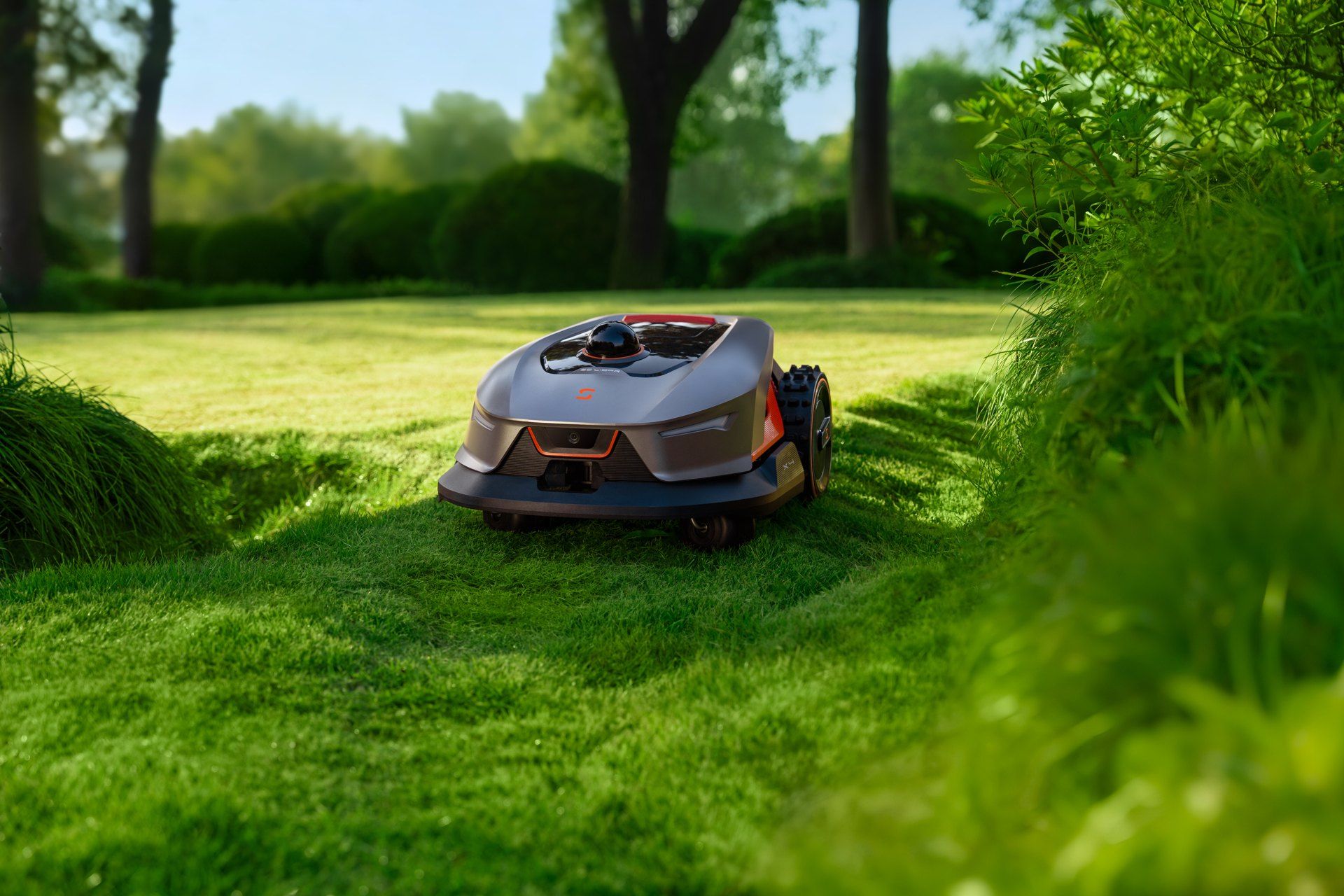 Sunseeker Elite X4 robot mower with its LiDAR sensor in a narrow strip of lawn between plants