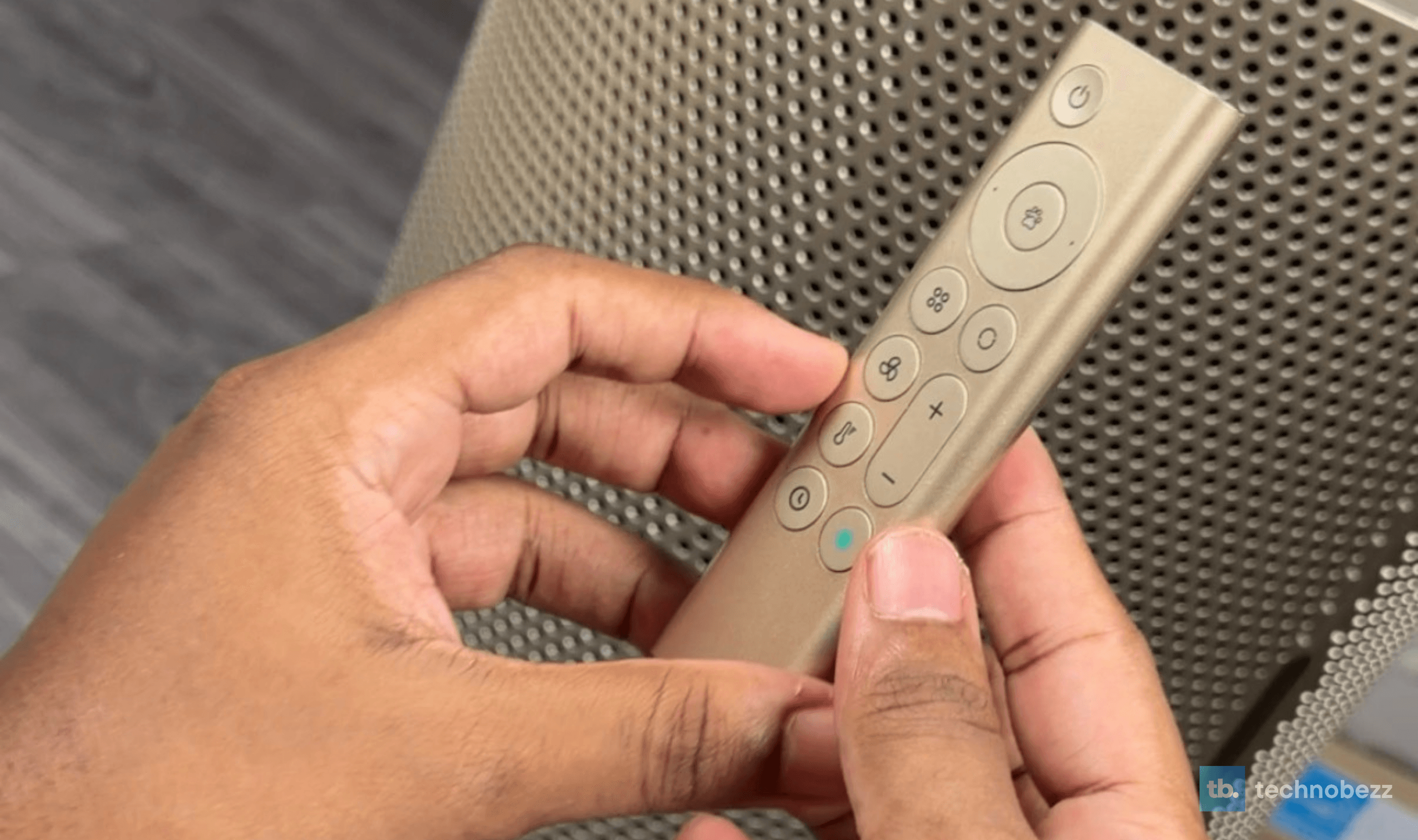Hand holding the Dreame AirPursue PM20's champagne remote control