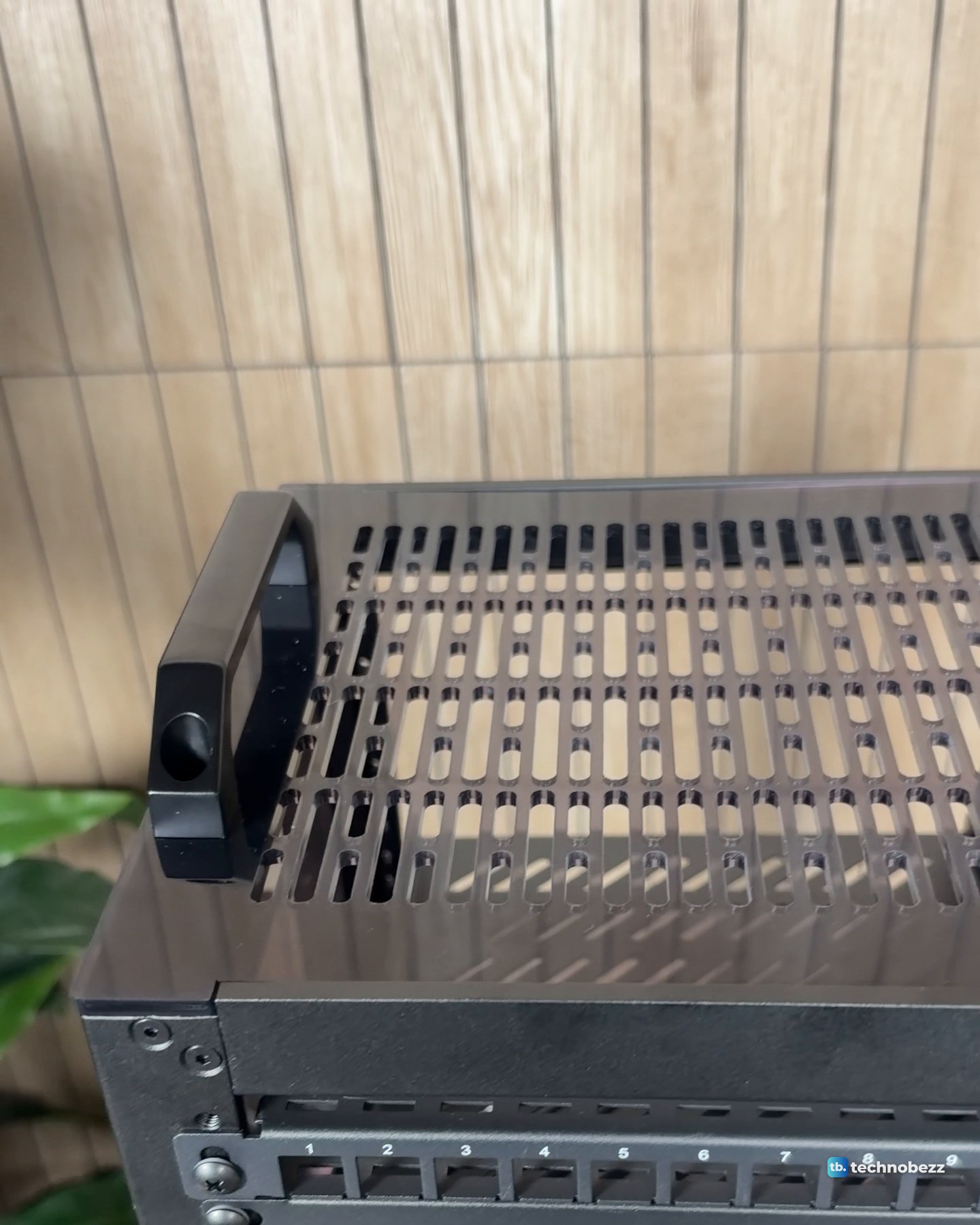 The vented top plate of the 10-inch rack with a black carry handle screwed on