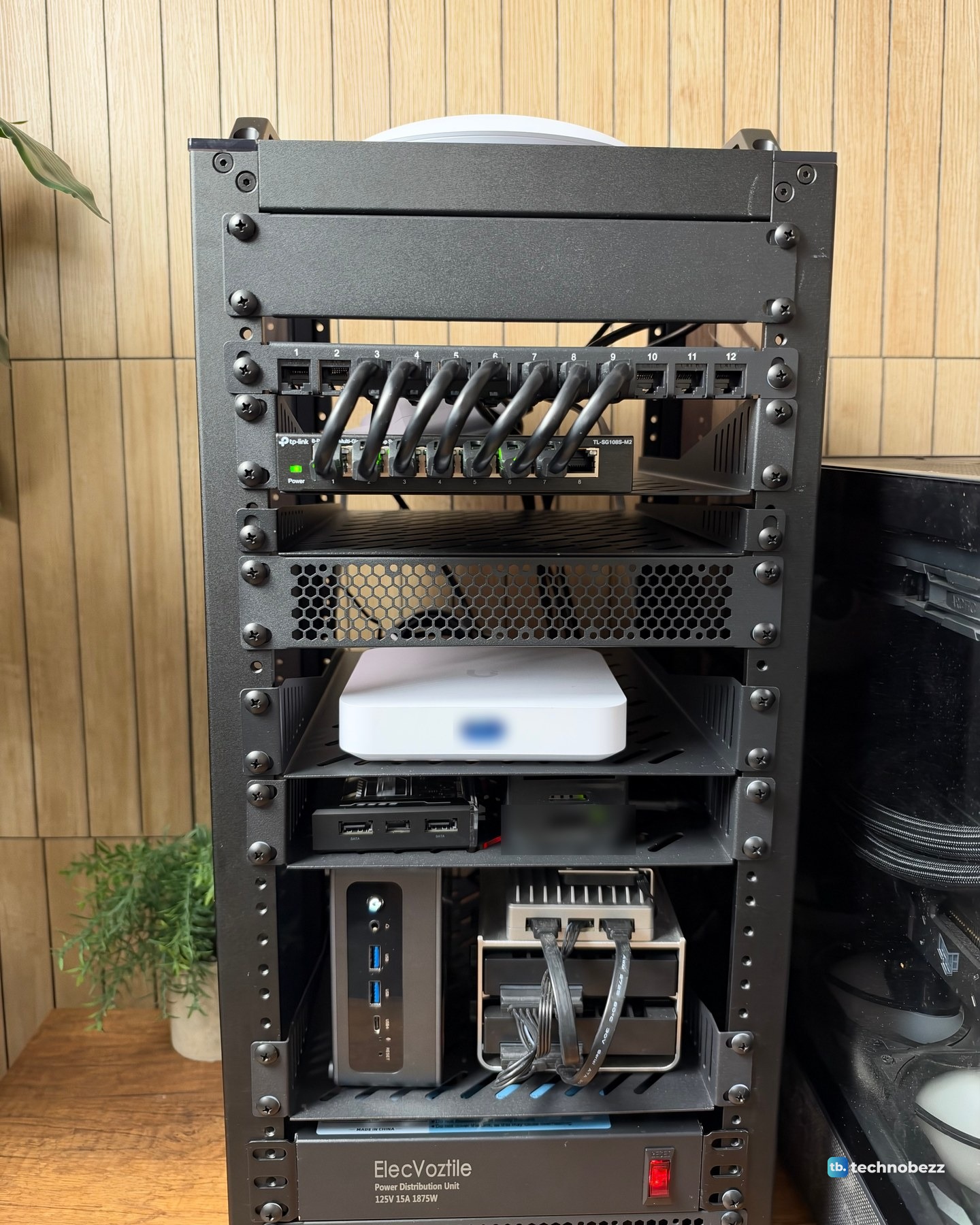 The front of the finished DeskPi RackMate T2 in daylight with seven short patch cables, the gateway, small computers and power strip