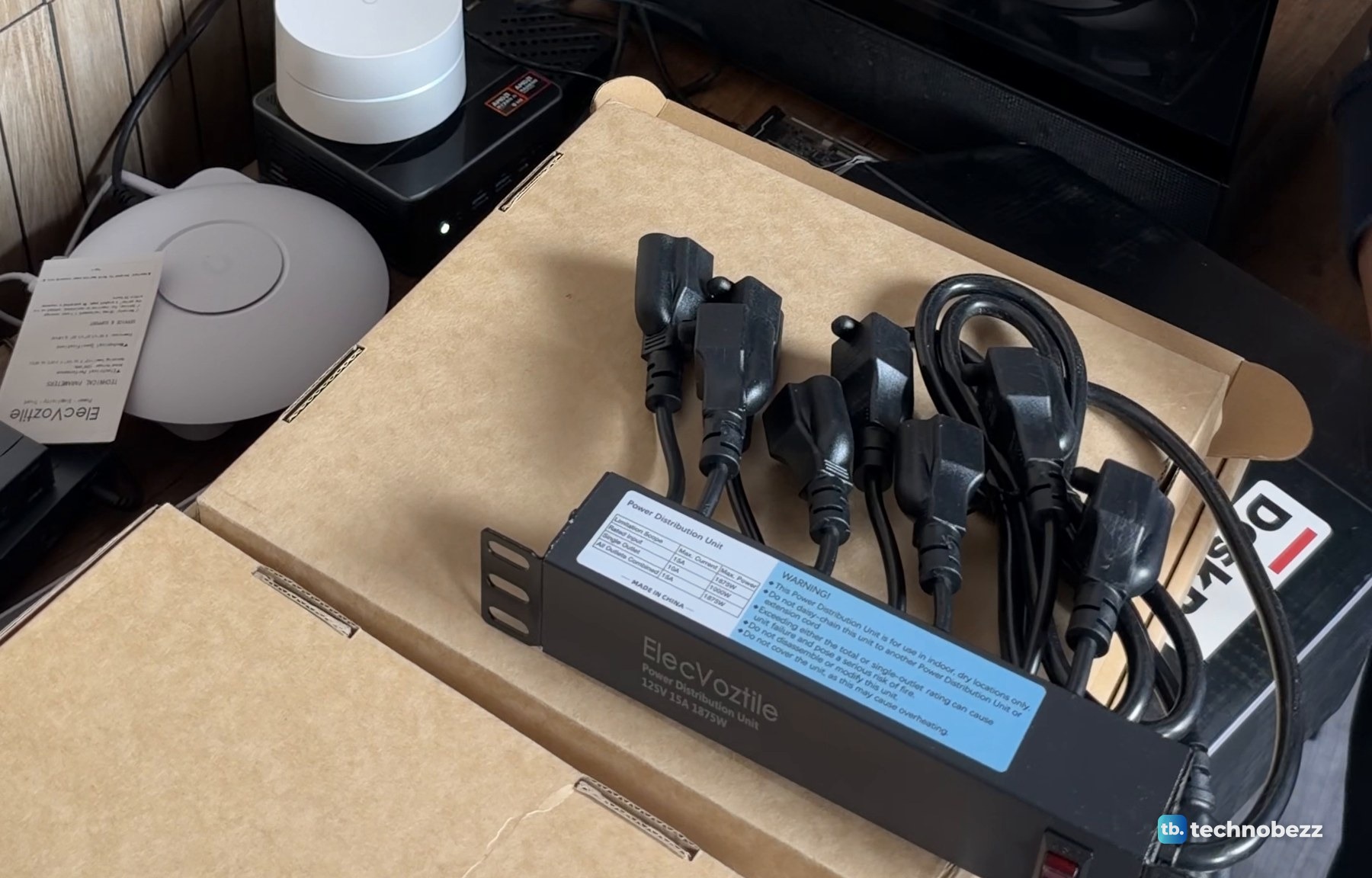 The ElecVoztile 10-inch power distribution unit on its box with a bundle of short black power cords