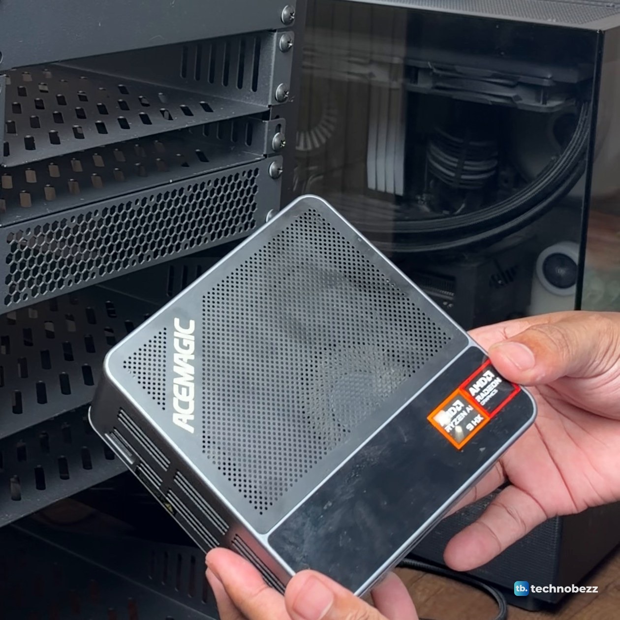 Hands holding the ACEMAGIC F5A mini PC, showing its vented top and AMD Ryzen sticker