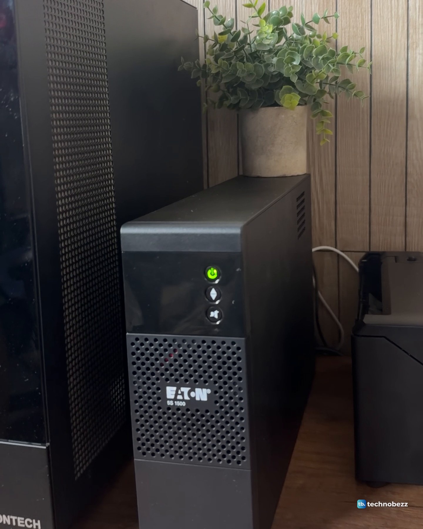 The black Eaton 5S 1500 UPS standing on the desk beside the side of the black tower PC