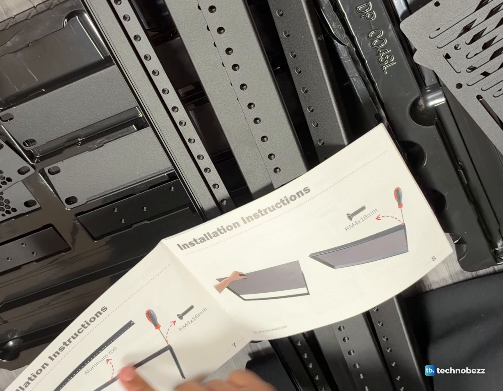The DeskPi RackMate T2 printed manual open at its installation pages beside the rack rails in the foam tray