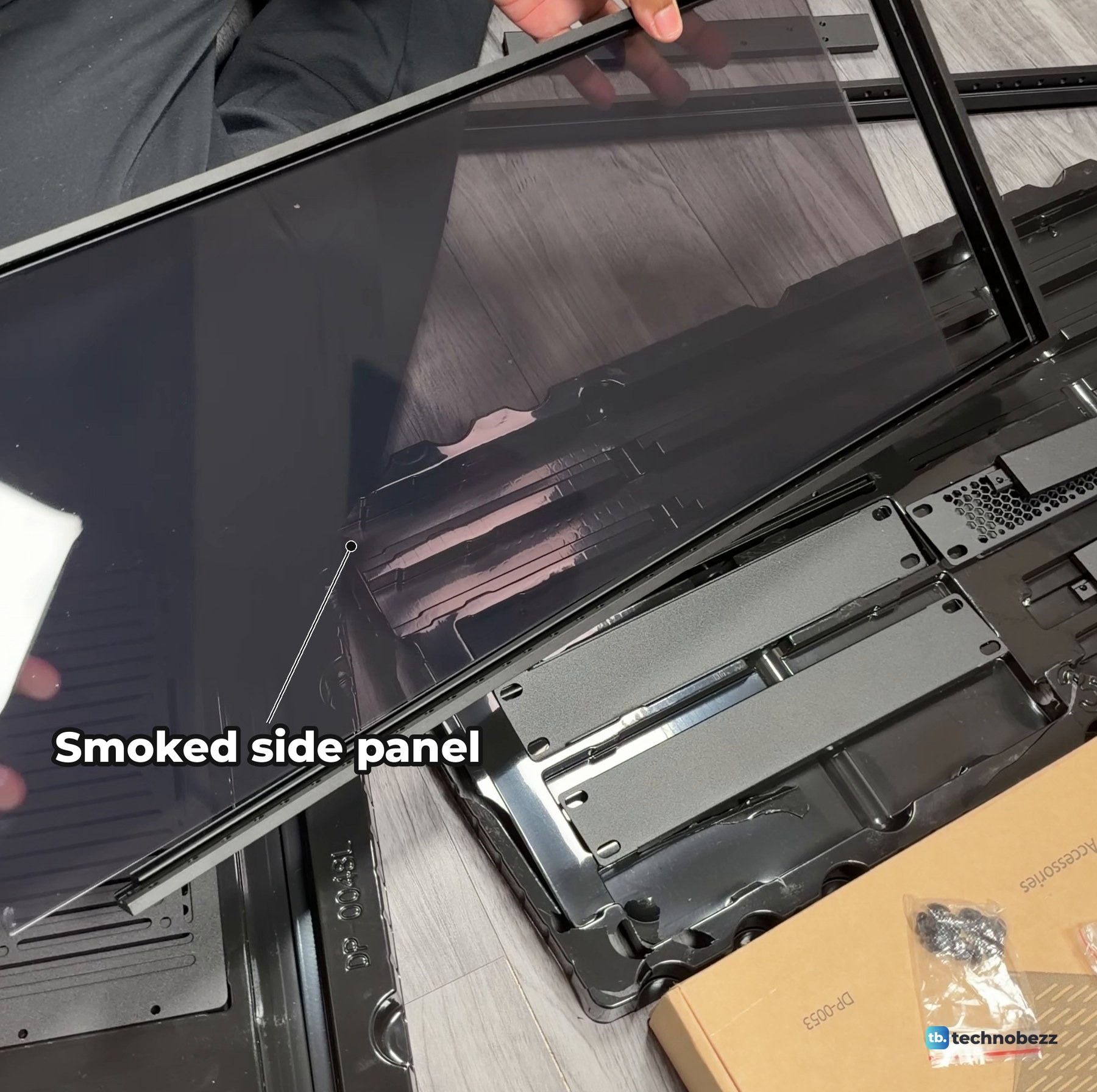 A smoked acrylic side panel sliding into the grooves of a DeskPi RackMate T2 rail frame