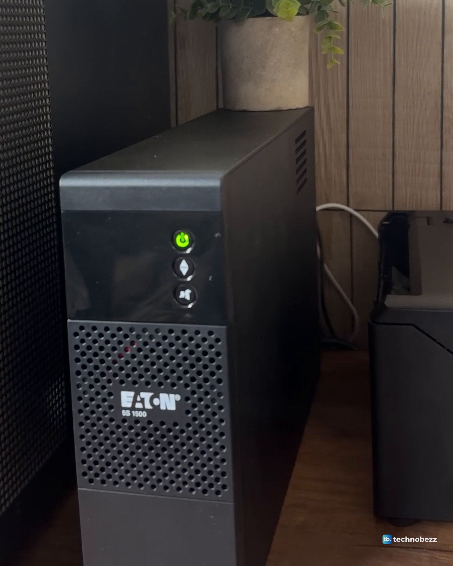 The Eaton 5S 1500 UPS standing beside the black mesh side panel of the main server, its power button glowing green