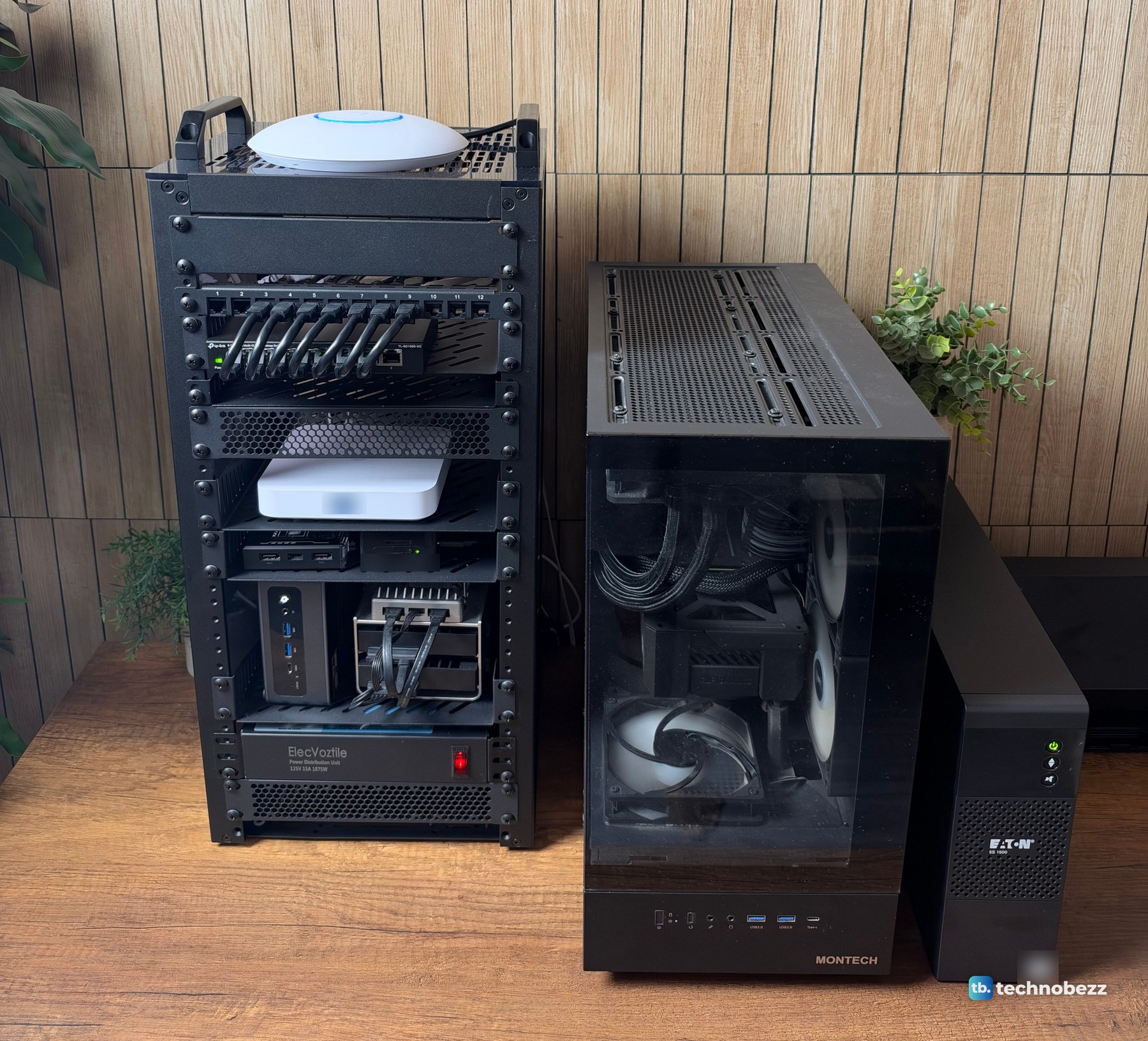 The 10-inch rack, the black MONTECH tower PC and the Eaton 5S 1500 UPS side by side on a wood desk against a slatted wall
