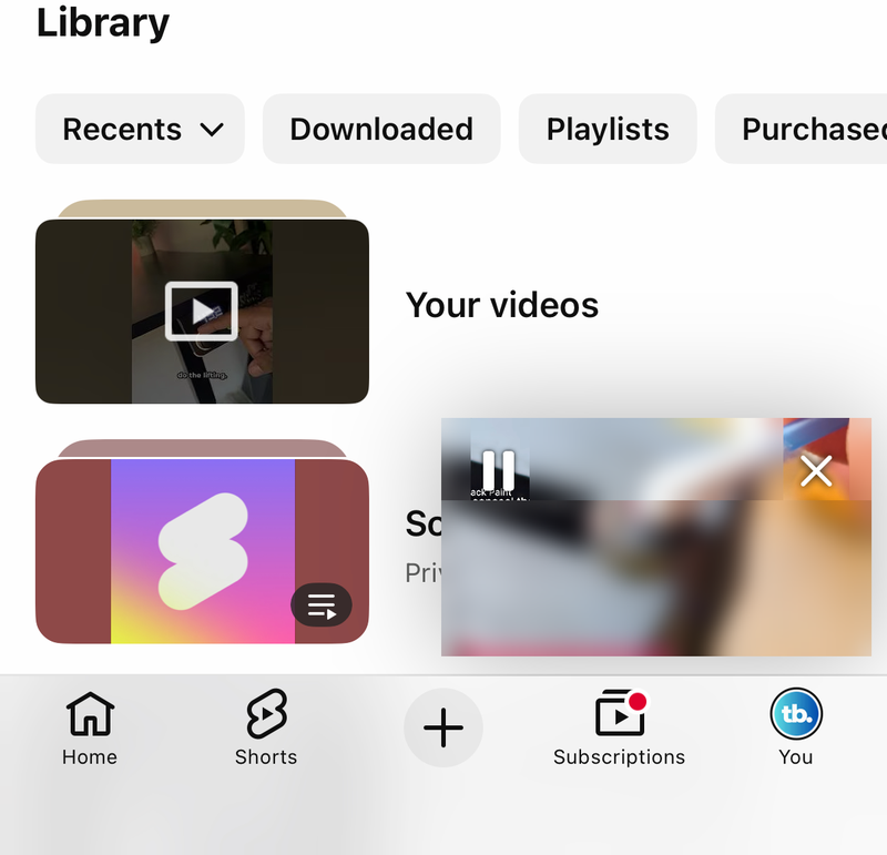 YouTube You tab on iPhone with the floating miniplayer card in the lower right corner