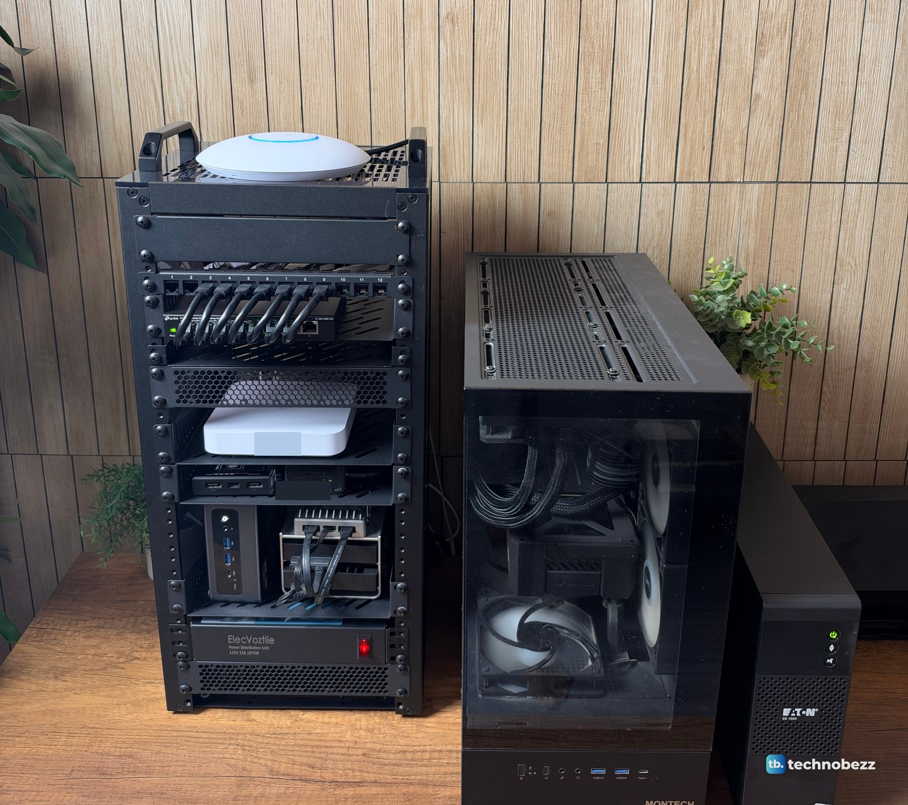 A 10-inch home lab rack, a black tower PC and an Eaton UPS side by side on a wood desk