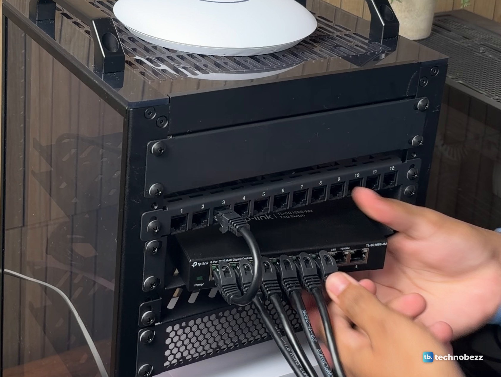 One looped jumper connects the patch panel to the switch while other cables hang from the switch ports