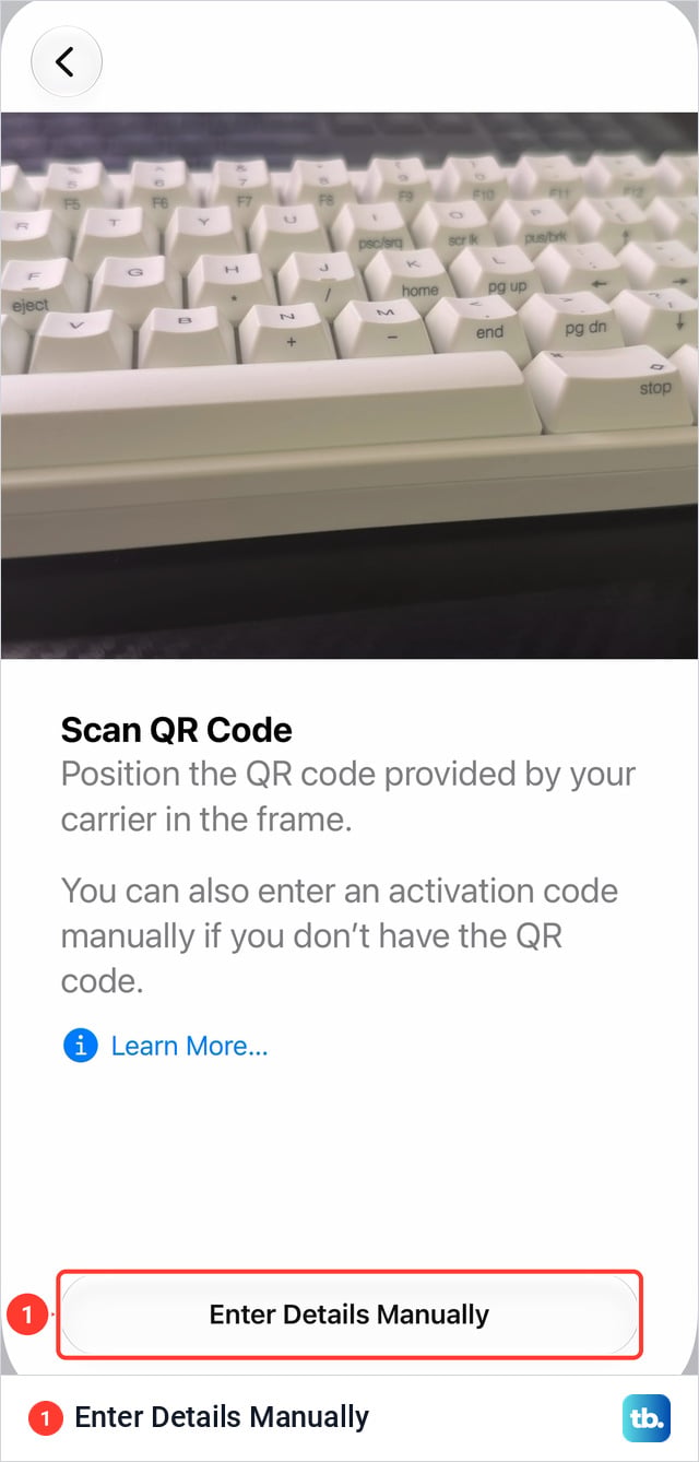 Scan QR Code screen on an iPhone 18 Pro Max with the camera view at the top pointed at a keyboard, the instruction text below it and an Enter Details Manually button at the bottom