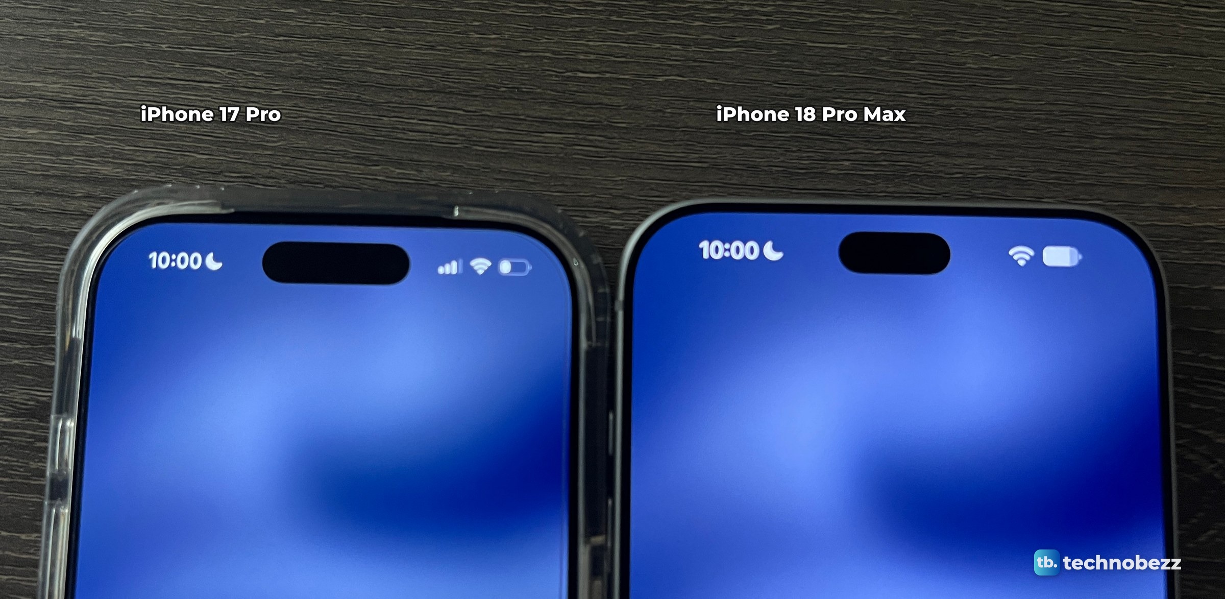 Straight-down photo of an iPhone 17 Pro in a clear case beside an iPhone 18 Pro Max, both with an empty Dynamic Island