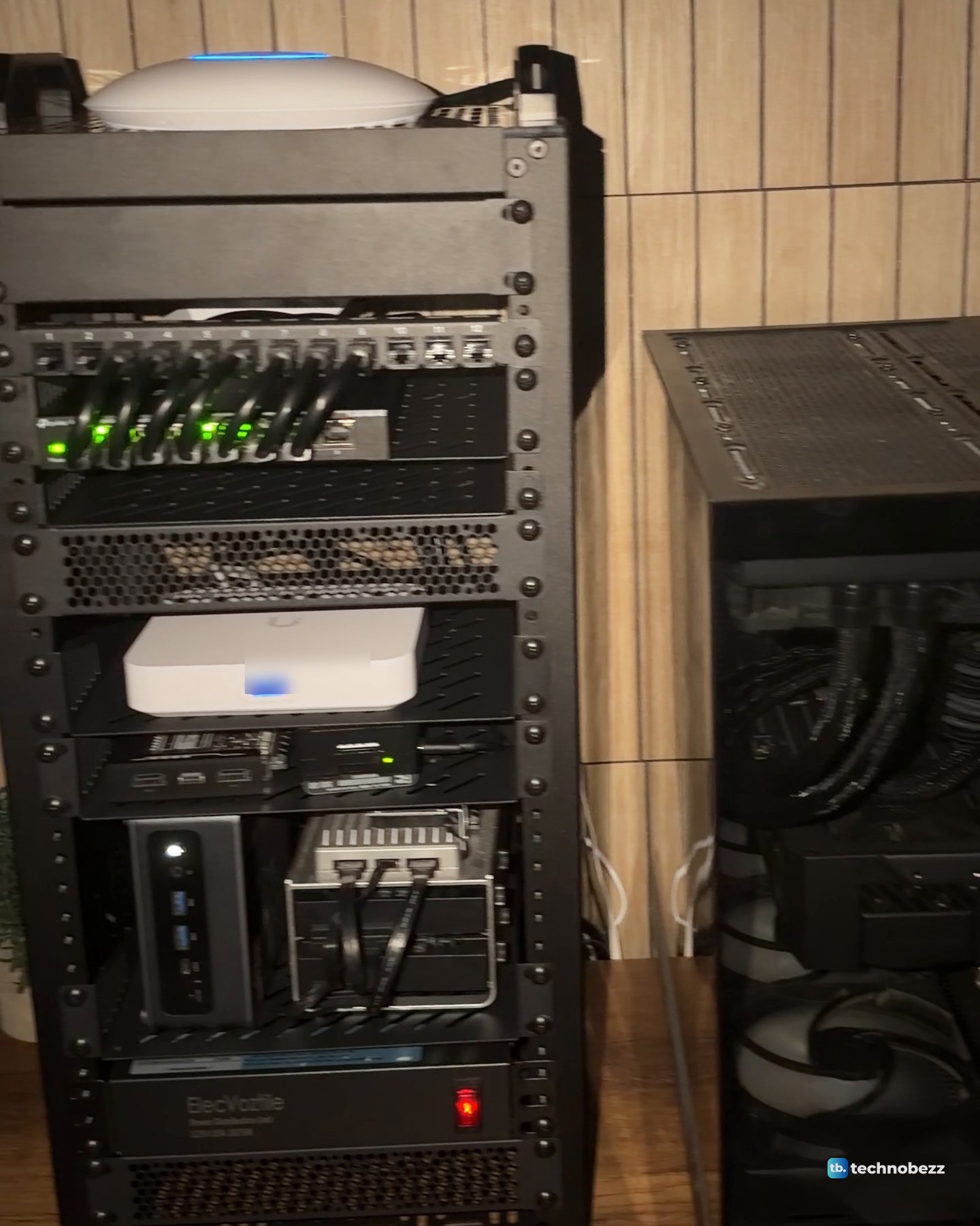The 10-inch rack in a dim room at night, with green switch lights, the blue light of the access point on top and the main server beside it