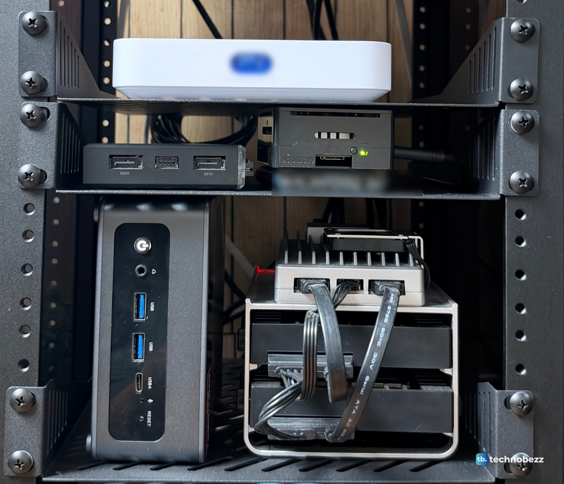 Rack shelves holding a white gateway, two small black boards, a black mini PC and a silver finned board in a stand