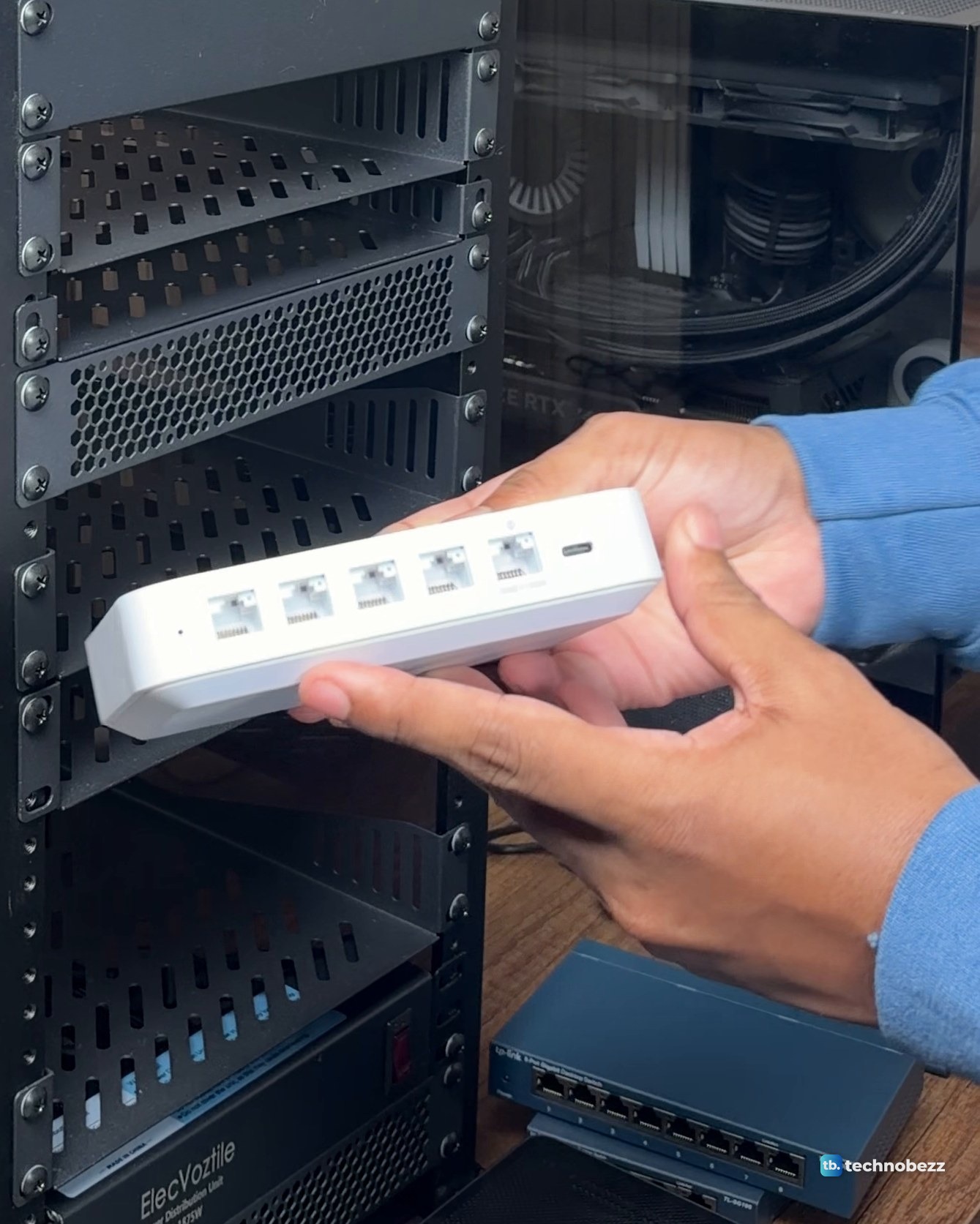 The white UniFi Cloud Gateway Ultra held in two hands, showing its row of five network ports and a USB-C power port