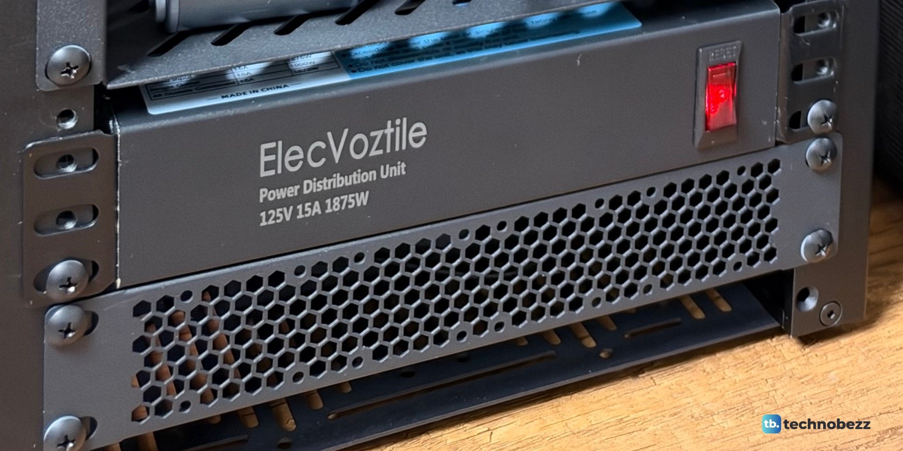 The ElecVoztile power distribution unit with its red front switch, above the vented bottom panel of the rack