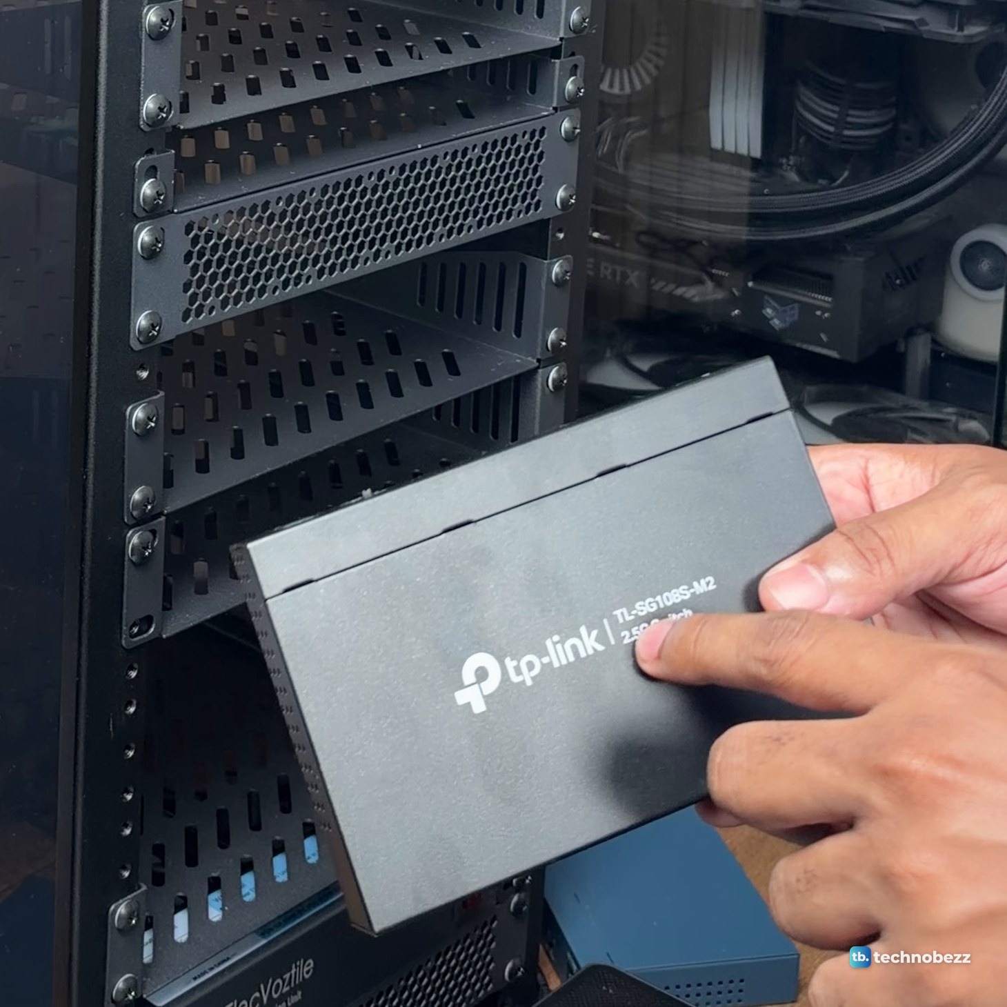 A hand holding the black TP-Link TL-SG108S-M2 switch with its model name on the top
