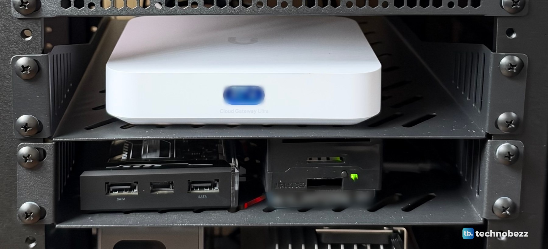 The white UniFi Cloud Gateway Ultra on a shelf, and below it the black ZimaBlade with SATA ports and the Raspberry Pi 5 in a black case