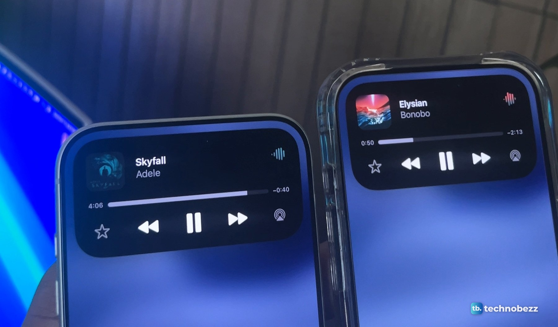 iPhone 18 Pro Max on the left and iPhone 17 Pro in a clear case on the right, each with the Dynamic Island expanded into a music player showing a song title, a progress bar and playback buttons