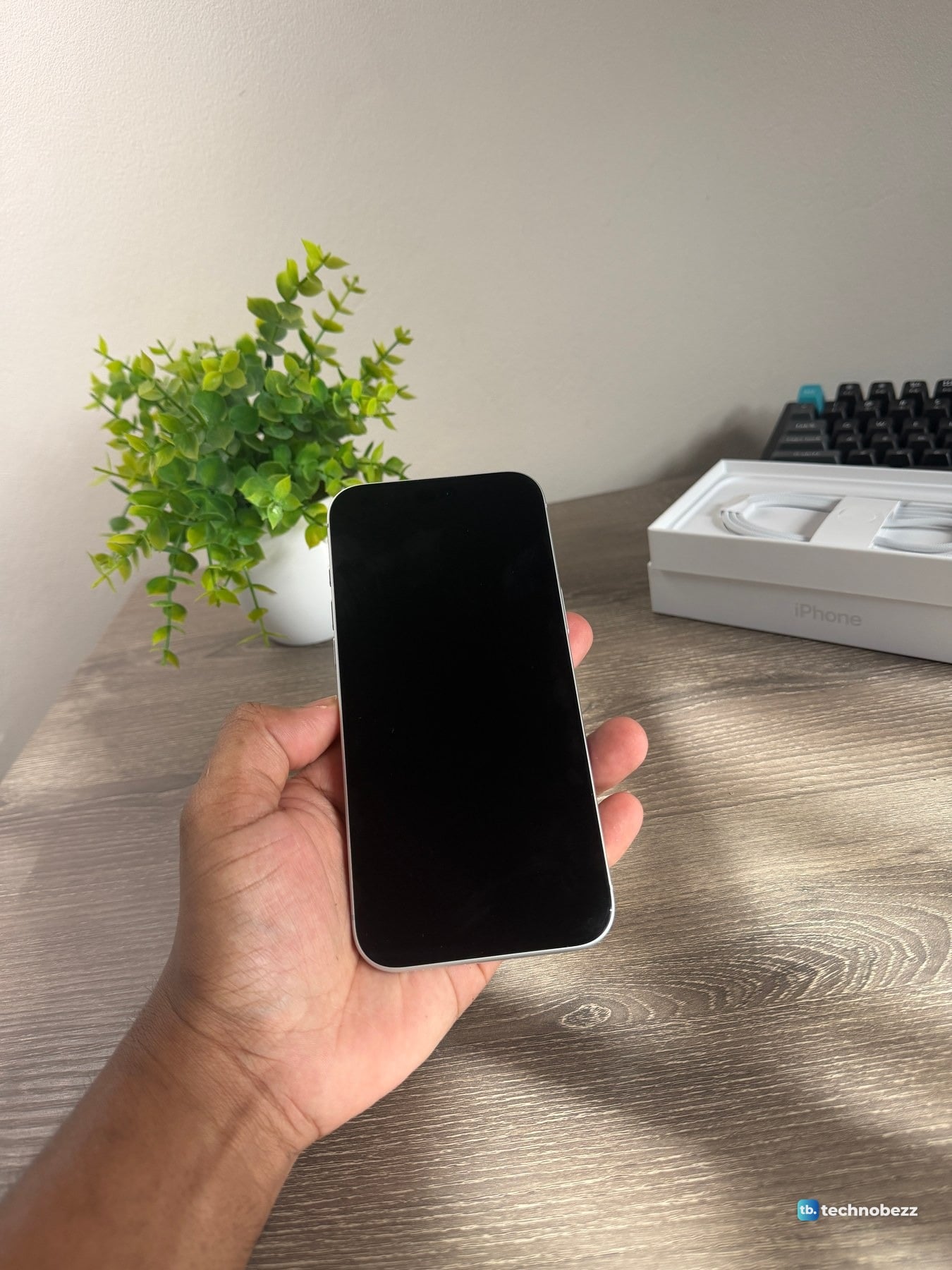 Front of the iPhone 18 Pro Max with the screen off, held in a hand above a desk