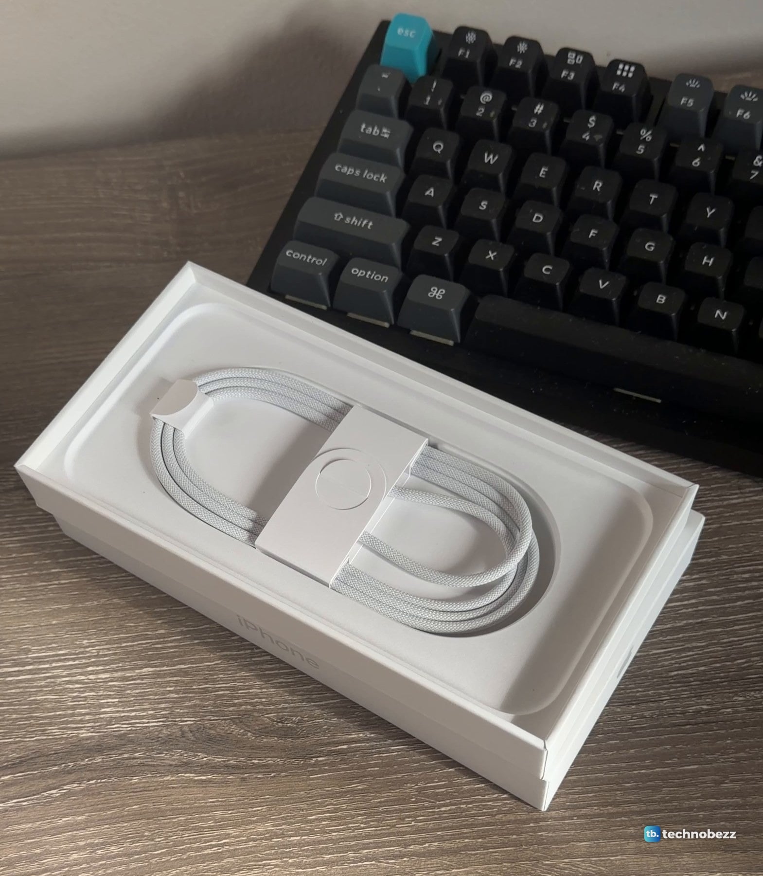 White woven USB-C cable coiled in a molded paper tray that sits in the iPhone 18 Pro Max box