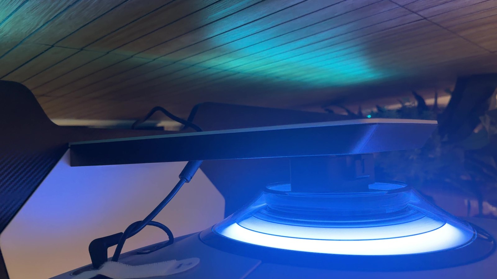 The back of the Samsung Odyssey OLED G9 with its blue lighting ring glowing around the stand mount